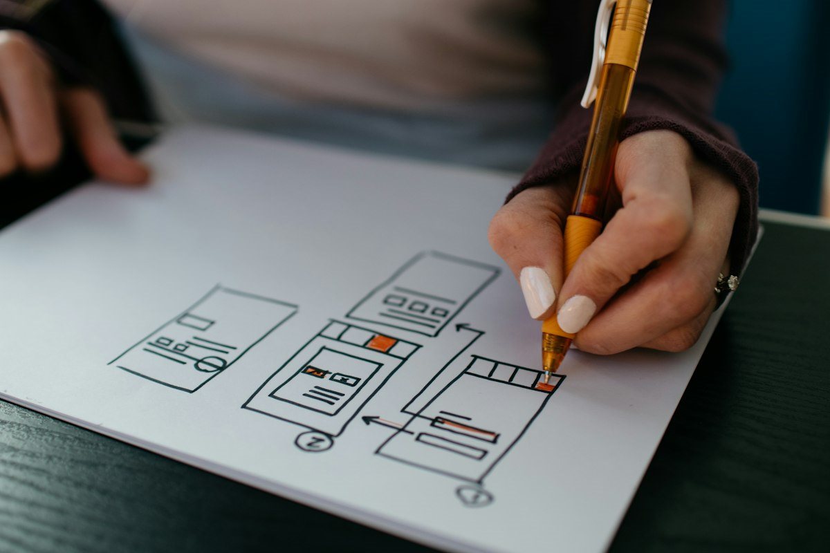 Product designer mapping an application workflow on paper